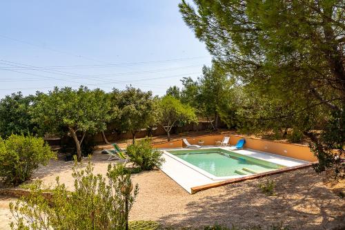 a swimming pool in a yard with trees at Villa Caterina in La Maddalena