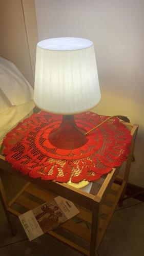 a lamp on a table with a red blanket on it at Alba central City in Palermo
