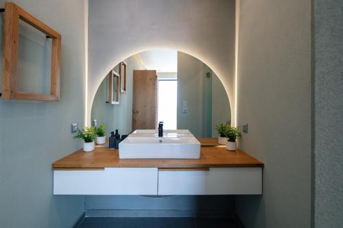 a bathroom with a white sink and a mirror at Seafront elegant villas, with infinity pools & devine views! in Agios Pavlos