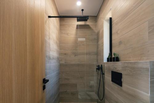 a shower in a bathroom with wooden walls at Seafront elegant villas, with infinity pools & devine views! in Agios Pavlos