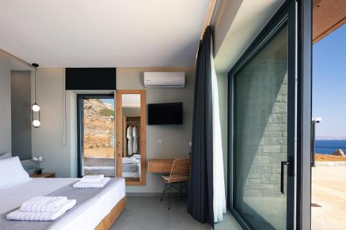 a bedroom with a bed and a view of the ocean at Seafront elegant villas, with infinity pools & devine views! in Agios Pavlos