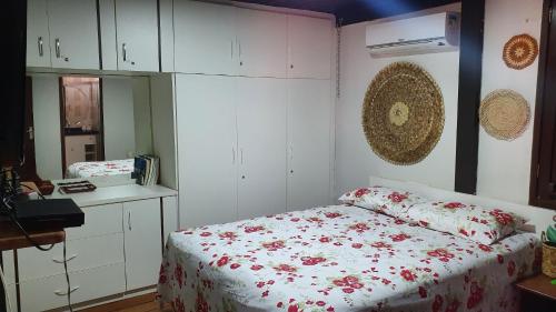 een slaapkamer met een bed met rode bloemen erop bij Chalé em Barreirinhas 599,00 6 pessoas in Itaqui