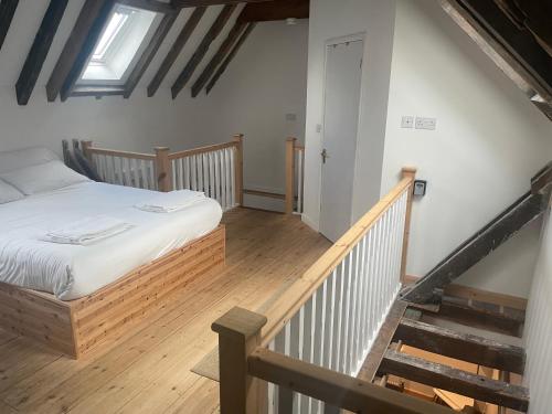 a bedroom with a bed and a stair case at Loaf 2 at The Old Granary Converted Town Centre Barn in Beverley