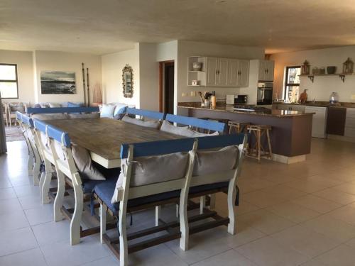 a dining room with a large wooden table and chairs at St Francis Bay House On The Canal in St Francis Bay