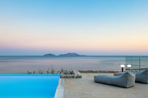 Seafront elegant villa, with infinity pool & devine views! في أجيوس بافلوز: مسبح مطل على المحيط