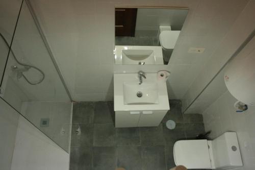 a bathroom with a sink and a toilet and a mirror at Golondrinas de Malaga "Apartamentos con mucho Arte" y terraza solarium en coliving in Málaga