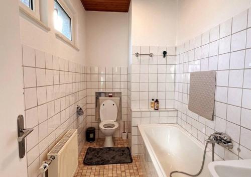 a bathroom with a toilet and a tub and a sink at Ruhige freistehender Bungalow mit Parkplatz in Beckum