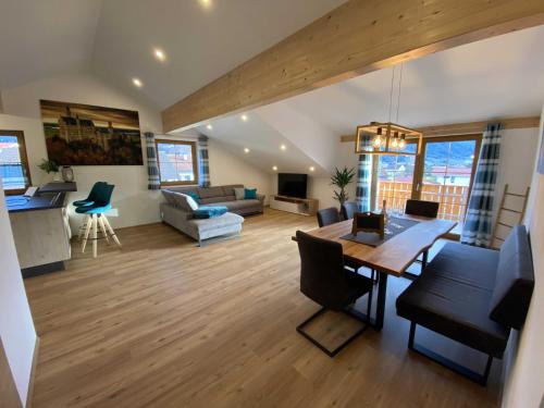 a living room with a table and a dining room at Ferienwohnung Hipp - Bockstallsee in Halblech