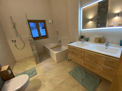 a bathroom with a sink and a tub and a toilet at Ferienwohnung Hipp - Bockstallsee in Halblech