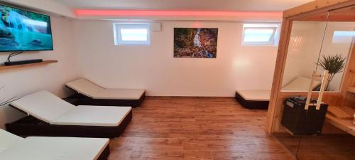 a living room with white furniture and a tv at Ferienwohnung Hipp - Bockstallsee in Halblech