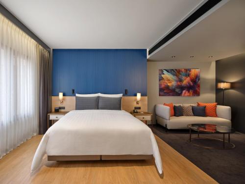 1 dormitorio con 1 cama blanca grande y 1 sofá en Sindhorn Midtown Hotel Bangkok, Vignette Collection - an IHG Hotel en Bangkok
