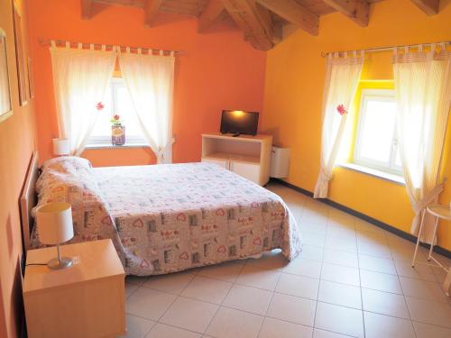 a bedroom with a bed and two windows at Mini-Appartamenti, Camere Lanterna Blu in Mombello Monferrato