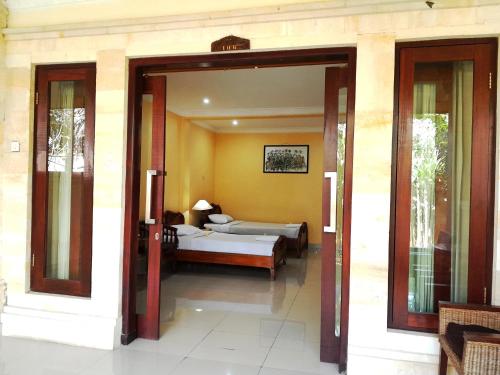 eine offene Tür zu einem Schlafzimmer mit einem Bett in der Unterkunft Panorama Hotel in Ubud