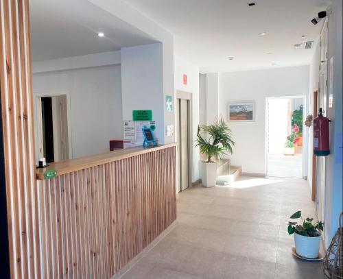 a lobby of a hospital with a counter and plants at Hotel Senderos in Agua Amarga