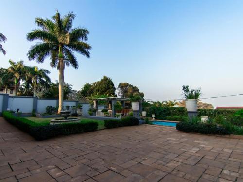 a patio with a palm tree in the background at Royal Guesthouse in Mtunzini