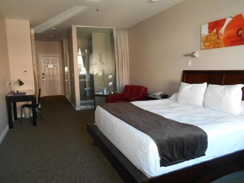 a hotel room with a large bed and a red chair at Century Casino & Hotel Cripple Creek in Cripple Creek