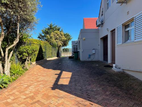 a brick driveway next to a white building at Sedgefield Lagoon Hideout - Kingfisher Drive in Sedgefield