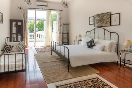 a bedroom with a bed and a large window at ama Stays and Trails Casa Kenzo, Kashid in Mumbai