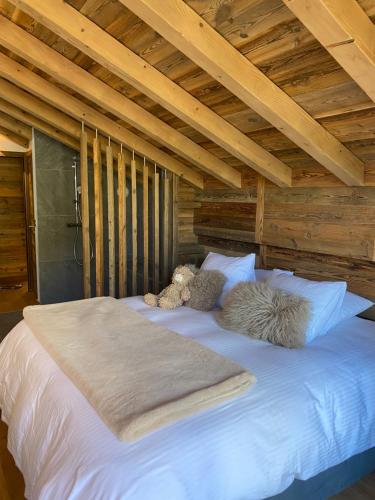 a large white bed with two stuffed animals on it at Chalet Neuf du Pape in Les Deux Alpes