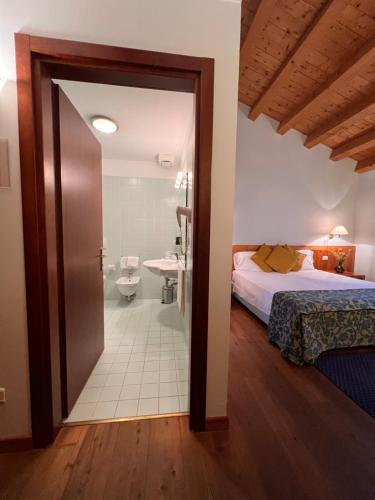 a bedroom with a bed and a bathroom at Hotel Due Torri Tempesta in Noale