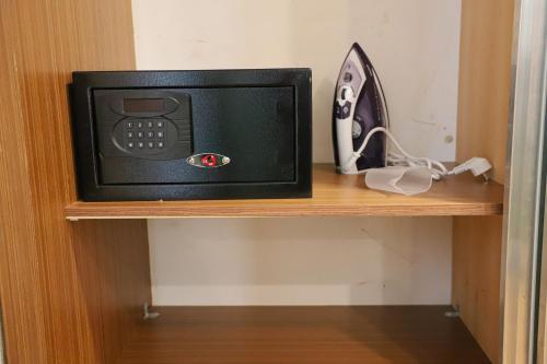 a microwave sitting on top of a wooden shelf at UNITED HOTEL INTERNATIONAL in Yaoundé