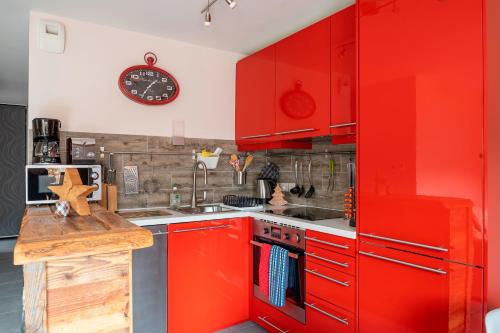 - une cuisine rouge avec des placards rouges et un évier dans l'établissement Apartment Marmottes Suisses, aux Gets