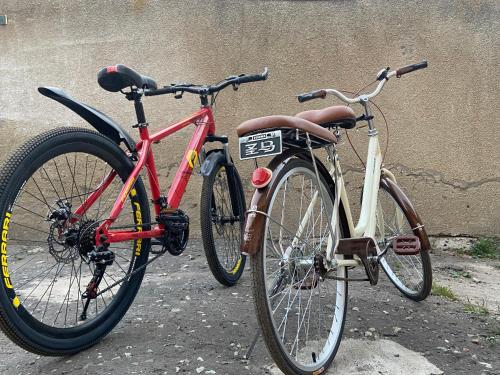 due biciclette parcheggiate l'una accanto all'altra accanto a un muro di Guest House a Sevan