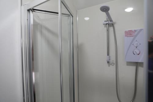 a shower with a glass door in a bathroom at Cosy Loft situated on shores of Lough Neagh 