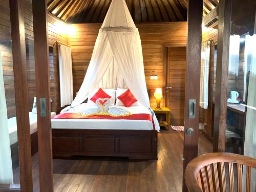 a bed with a canopy in a room at Bukit Permata Lembongan in Nusa Lembongan