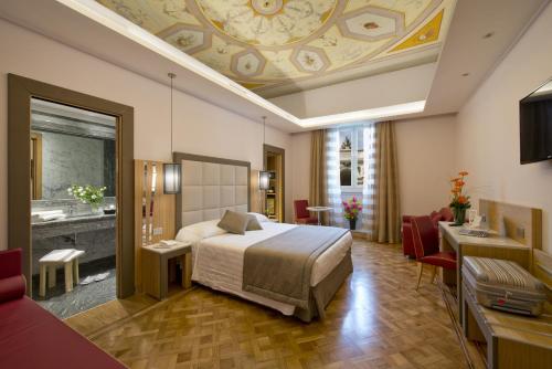 a hotel room with a bed and a bathroom at Hotel Giolli Nazionale in Rome