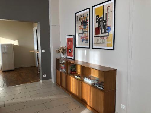 un salon avec une étagère et des photos murales dans l'établissement La Terrasse des bords du Cher, à Saint-Aignan