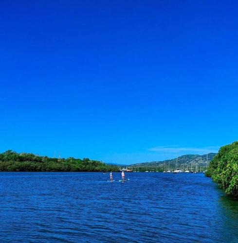 two people on a paddle board in the water at Apartamentos ipap luperon in Puerto de Luperon