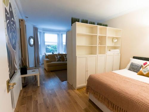 グラスゴーにあるPass the Keys West End Studio Kelvingrove Park Museumのベッドルーム1室(ベッド1台付)、ソファ付きのベッドルーム1室が備わります。