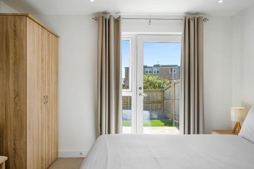 a bedroom with a bed and a sliding glass door at 5 The Dunes in Perranporth