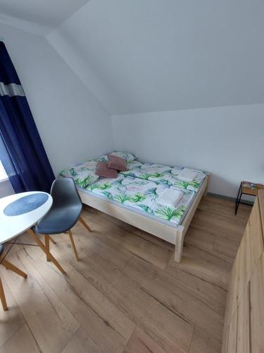 een bed in een kamer met een tafel en een stoel bij Studio u Beaty in Grywałd