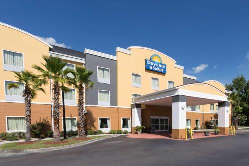 un hotel con palmeras frente a un edificio en Days Inn & Suites by Wyndham Savannah North I-95, en Port Wentworth