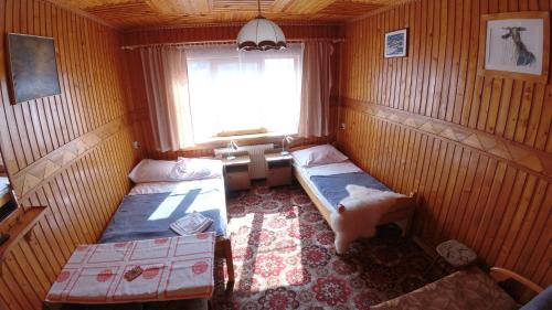 a small room with two beds and a window at Willa Pod Jesionami in Zakopane
