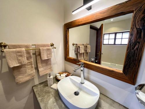 a bathroom with a white sink and a mirror at MILIMA Big 5 Safari Lodge in Hoedspruit