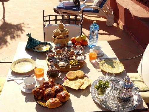 een tafel met borden eten erop bij Riad Ramzi in Marrakesh