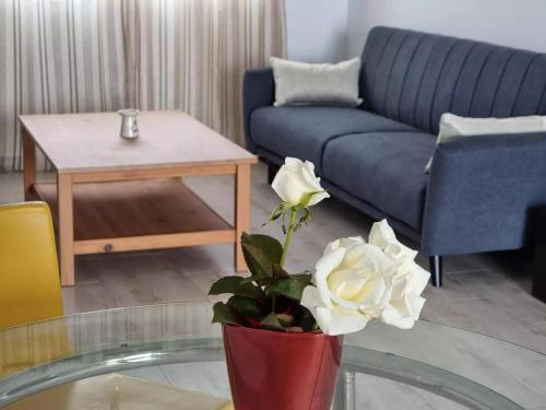 un soggiorno con divano blu e vaso con fiori di Casa Abubilla a Nazaret