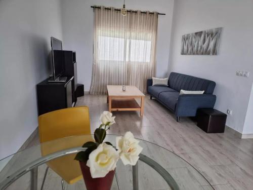 Casa Abubilla في Nazaret: غرفة معيشة مع أريكة زرقاء وطاولة زجاجية