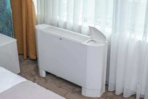a white air conditioner sitting next to a window at Hotel IDEAL Deluxe in Novi Pazar
