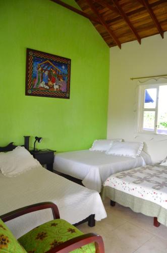 a green room with two beds and a picture on the wall at Finca Azulinas in La Tebaida