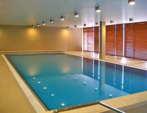 a large swimming pool in a building at Apartman 4 you Wellness in Budapest