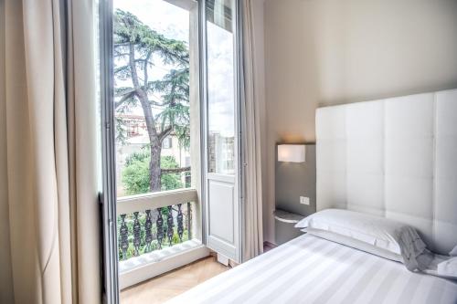 a bedroom with a bed and a large window at Hotel Ariele in Florence