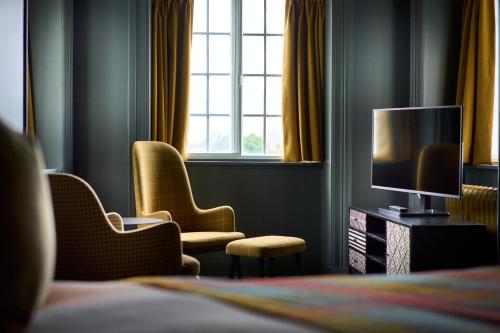 a hotel room with two chairs and a television at Royal Marine Hotel in Brora