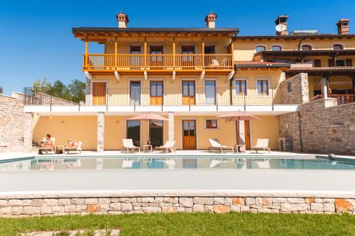 a villa with a swimming pool in front of a building at Hotel & Restaurant Pahor in Doberdò del Lago