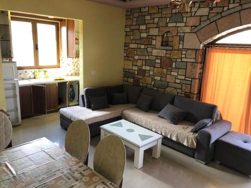 a living room with a couch and a stone wall at Jasmina Apartments in Ksamil