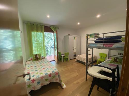 1 dormitorio con literas, mesa y silla en Precioso apartamento con vistas montaña y rio, en Ribes de Freser