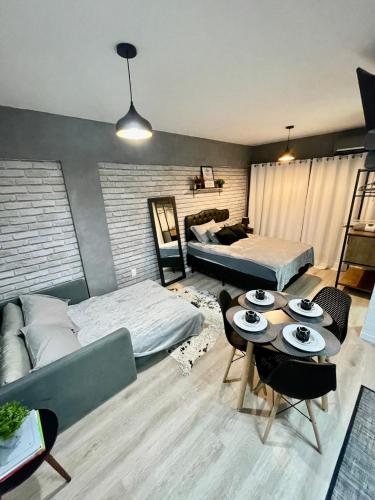 a living room with two beds and a table at Loft Studio 308 no Kobrasol à 7km de Floripa in São José